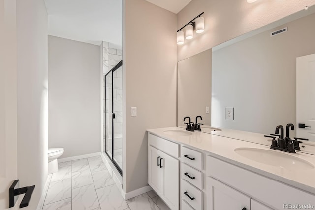 bathroom featuring vanity, toilet, and a shower with door