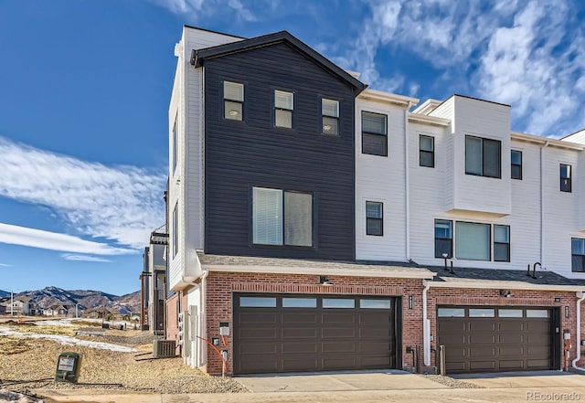 view of front of house featuring central AC, a garage, and a mountain view