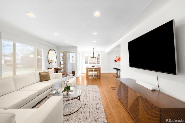 3925 Newland St, Wheat Ridge, CO 80033 - living area featuring light wood-style floors, healthy amount of natural light, recessed lighting, baseboards, and a chandelier