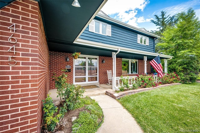 4645 W Temple Pl, Denver, CO 80236 - property entrance with brick siding, a yard, and a porch