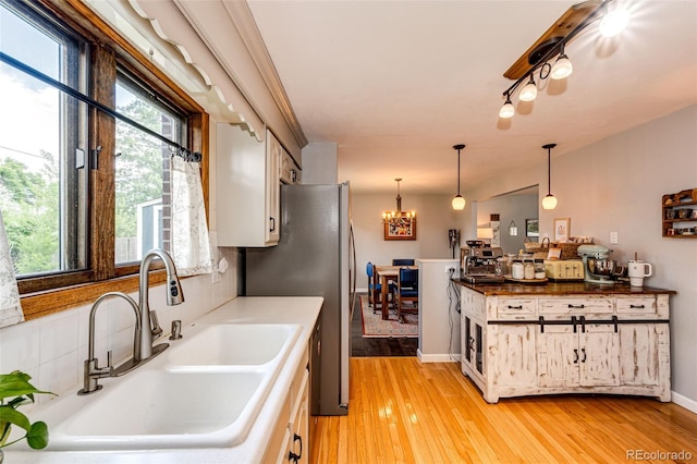 4645 W Temple Pl, Denver, CO 80236 - kitchen with freestanding refrigerator, a chandelier, light wood finished floors, and decorative light fixtures