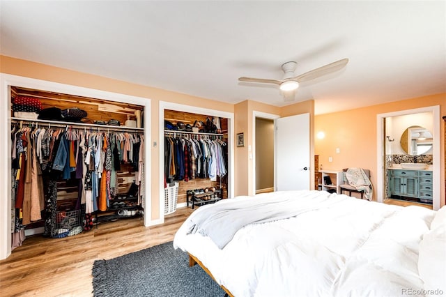 4645 W Temple Pl, Denver, CO 80236 - bedroom featuring two closets, wood finished floors, connected bathroom, and ceiling fan