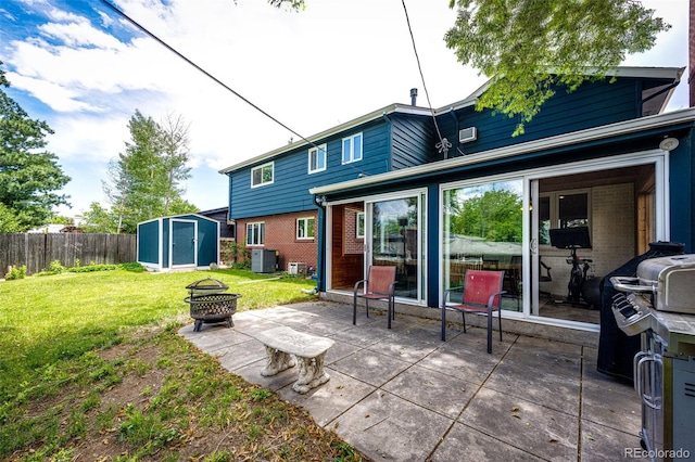 4645 W Temple Pl, Denver, CO 80236 - back of property featuring a shed, a fire pit, brick siding, a patio, and a sunroom