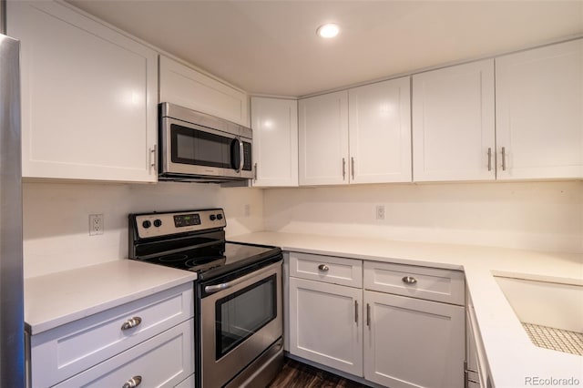4943 S Carson St Unit 207, Aurora, CO 80015 - kitchen featuring stainless steel appliances, white cabinets, light countertops, recessed lighting, and dark wood finished floors
