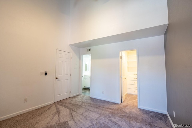 4943 S Carson St Unit 207, Aurora, CO 80015 - unfurnished bedroom featuring carpet flooring, a high ceiling, and ensuite bathroom