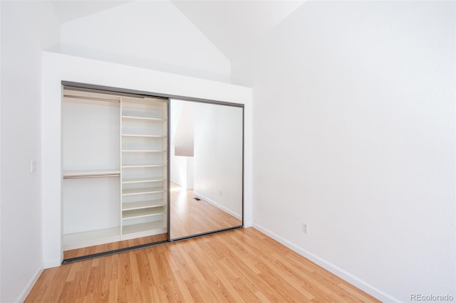 4943 S Carson St Unit 207, Aurora, CO 80015 - unfurnished bedroom with wood finished floors, a closet, and vaulted ceiling