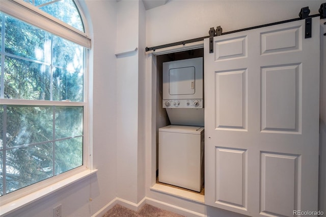 4943 S Carson St Unit 207, Aurora, CO 80015 - laundry room with stacked washer and clothes dryer, a barn door, and carpet flooring