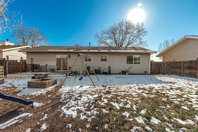 snow covered house featuring fence and a wooden deck