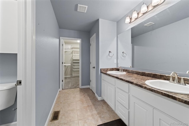 bathroom with tile patterned flooring, vanity, and toilet