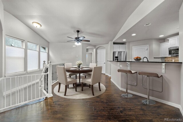 dining area featuring baseboards, a ceiling fan, lofted ceiling, dark wood-type flooring, and recessed lighting