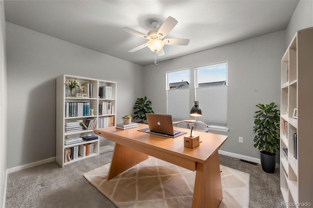 carpeted office space with ceiling fan