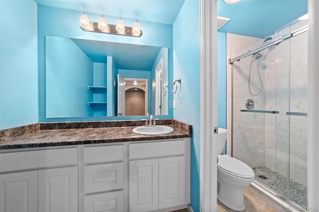 bathroom featuring toilet, tile patterned flooring, a textured ceiling, an enclosed shower, and vanity