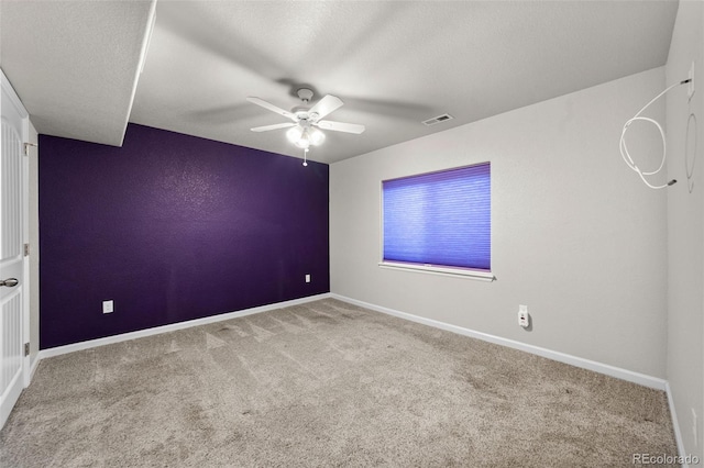 carpeted empty room featuring a textured ceiling and ceiling fan