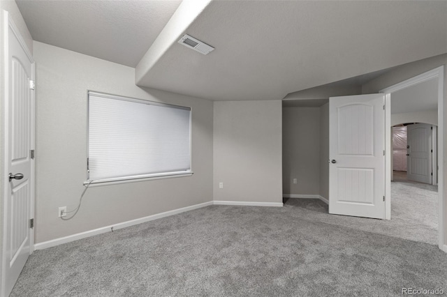 carpeted empty room featuring a textured ceiling