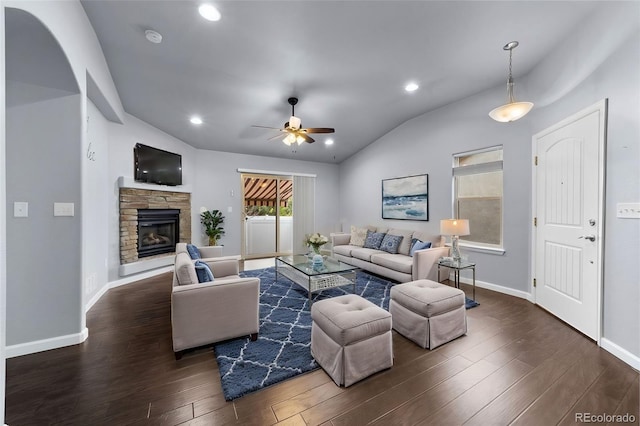 living area with vaulted ceiling, a fireplace, wood finished floors, and baseboards