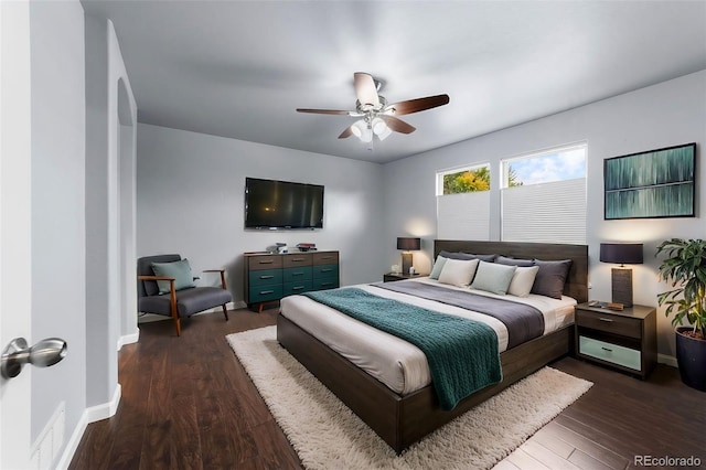 bedroom with ceiling fan, dark wood-style flooring, visible vents, and baseboards