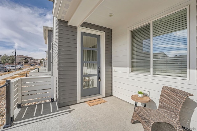 view of exterior entry featuring covered porch