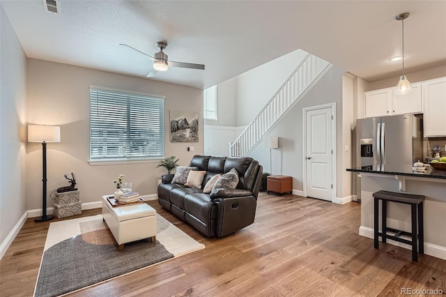 living room with ceiling fan and light hardwood / wood-style flooring