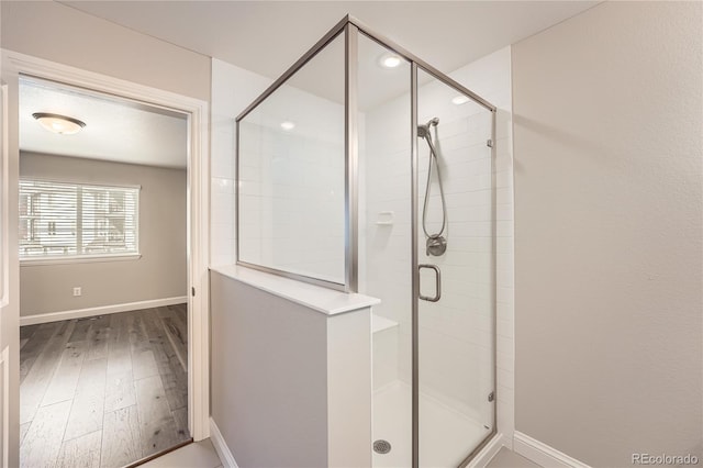 bathroom featuring an enclosed shower and wood-type flooring