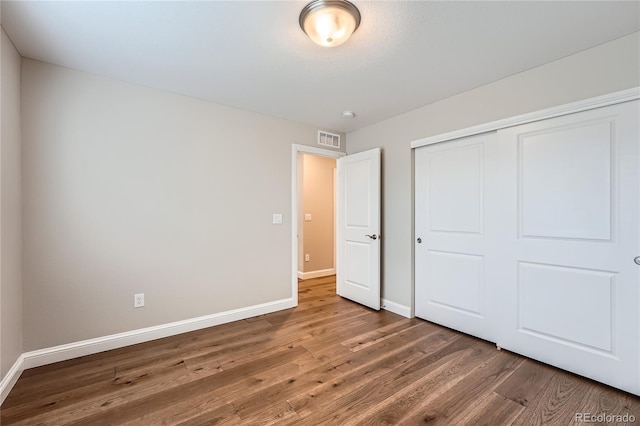 unfurnished bedroom featuring hardwood / wood-style flooring and a closet