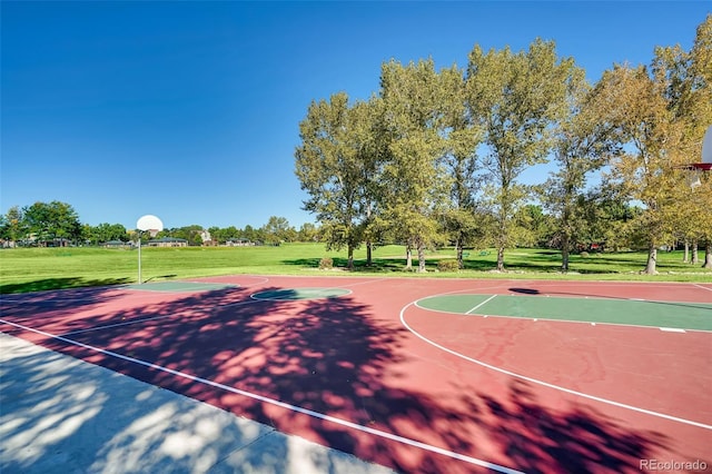 view of sport court with a lawn