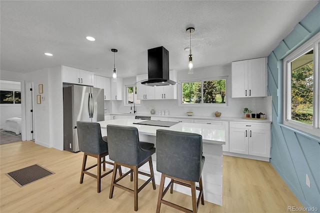 1173 Xenon St, Golden, CO 80401 - kitchen featuring island range hood, freestanding refrigerator, a sink, light countertops, and light wood finished floors