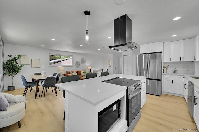 1173 Xenon St, Golden, CO 80401 - kitchen with appliances with stainless steel finishes, island exhaust hood, a kitchen island, light wood-style flooring, and recessed lighting