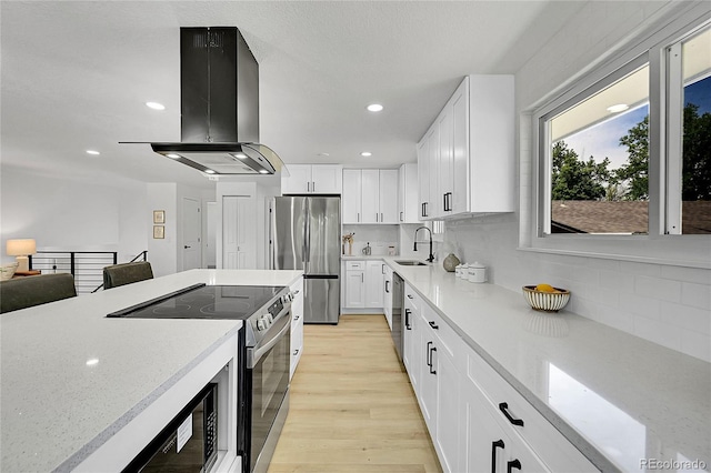 1173 Xenon St, Golden, CO 80401 - kitchen featuring stainless steel appliances, island exhaust hood, a sink, tasteful backsplash, and recessed lighting