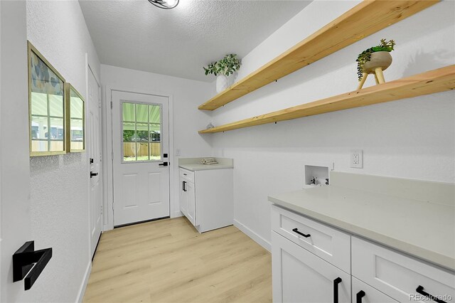 1173 Xenon St, Golden, CO 80401 - washroom with cabinet space, light wood-style floors, washer hookup, baseboards, and a textured ceiling