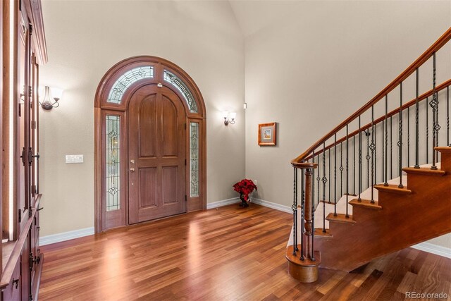 11406 Conifer Ridge Dr, Conifer, CO 80433 - entrance foyer with wood finished floors, stairway, baseboards, and high vaulted ceiling