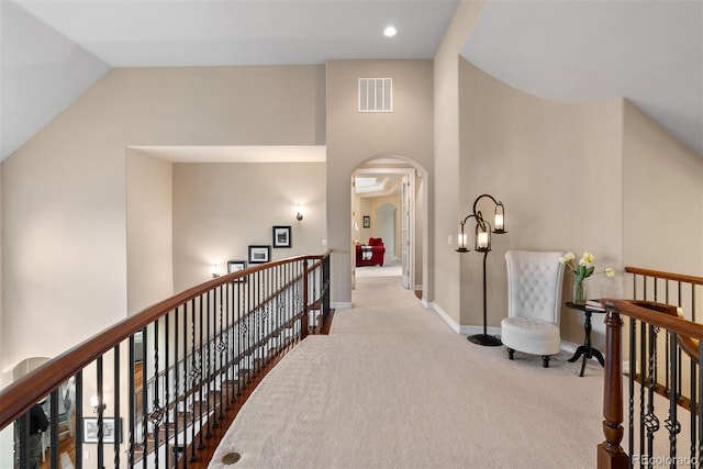 11406 Conifer Ridge Dr, Conifer, CO 80433 - hallway with an upstairs landing, carpet floors, arched walkways, baseboards, and high vaulted ceiling