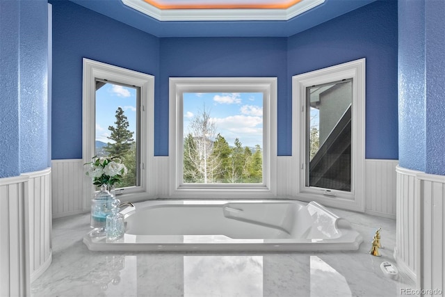 11406 Conifer Ridge Dr, Conifer, CO 80433 - full bath featuring wainscoting, healthy amount of natural light, a tub, and a textured wall