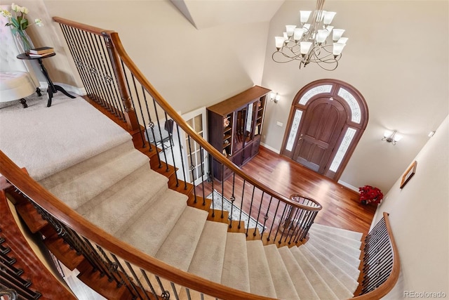 11406 Conifer Ridge Dr, Conifer, CO 80433 - foyer entrance with a chandelier, baseboards, wood finished floors, stairway, and a towering ceiling