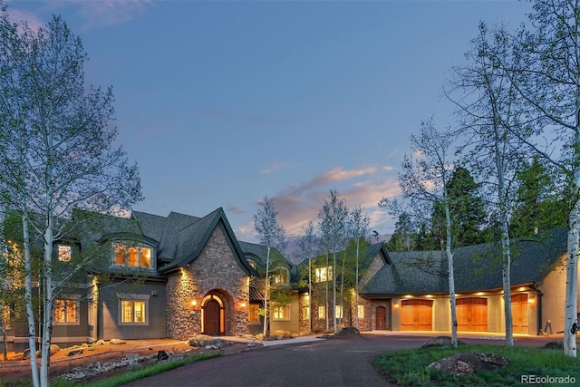 11406 Conifer Ridge Dr, Conifer, CO 80433 - french country inspired facade with stone siding, curved driveway, and stucco siding