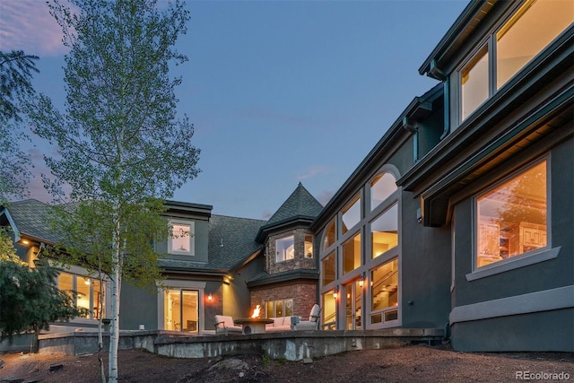 11406 Conifer Ridge Dr, Conifer, CO 80433 - back of house at dusk featuring stucco siding