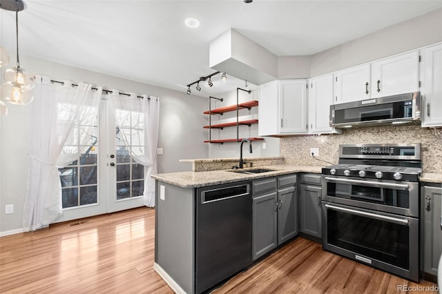 kitchen featuring gray cabinetry, white cabinetry, sink, hanging light fixtures, and stainless steel appliances