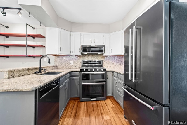 kitchen with gray cabinetry, white cabinets, sink, light wood-type flooring, and appliances with stainless steel finishes