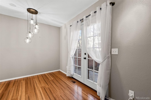 unfurnished room with wood-type flooring and french doors