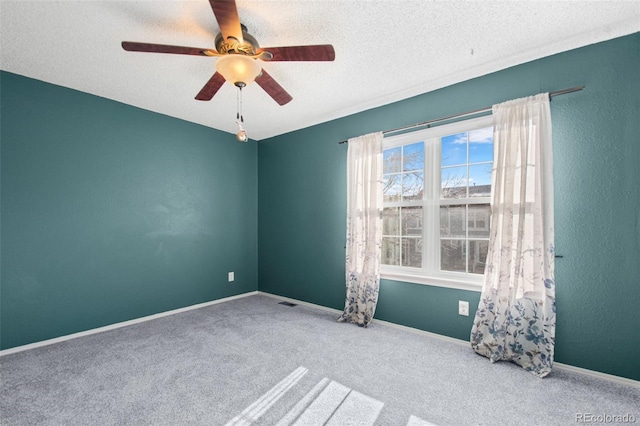 empty room featuring ceiling fan, carpet, and a textured ceiling