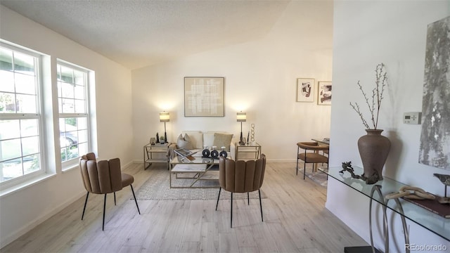 13833 W 68th Ave, Arvada, CO 80004 - living area with lofted ceiling, wood finished floors, and baseboards