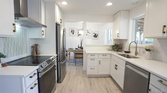 13833 W 68th Ave, Arvada, CO 80004 - kitchen featuring appliances with stainless steel finishes, wall chimney exhaust hood, a sink, light countertops, and recessed lighting