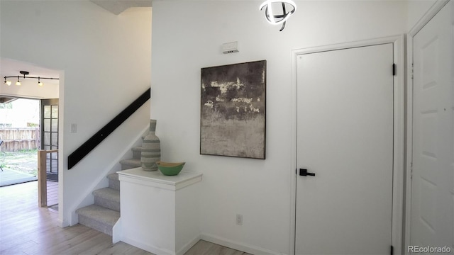 13833 W 68th Ave, Arvada, CO 80004 - stairway featuring wood finished floors, rail lighting, and baseboards