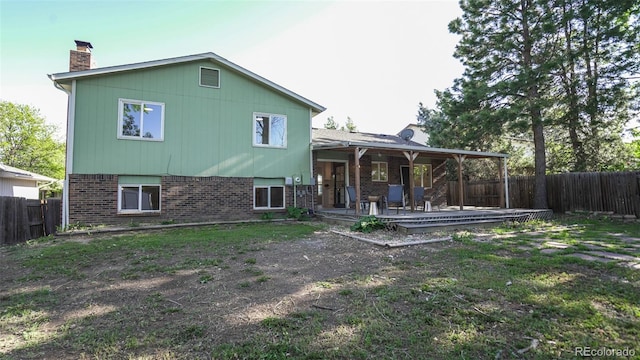 13833 W 68th Ave, Arvada, CO 80004 - back of property with brick siding, a chimney, and a fenced backyard