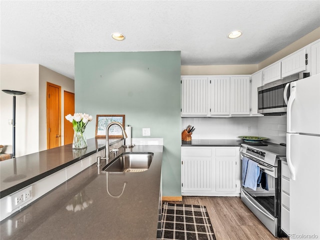 kitchen with white cabinetry, sink, decorative backsplash, light hardwood / wood-style floors, and stainless steel appliances