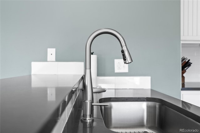 room details featuring sink and white cabinets