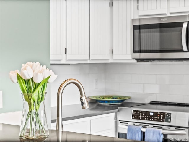 kitchen featuring stainless steel appliances, tasteful backsplash, and white cabinets