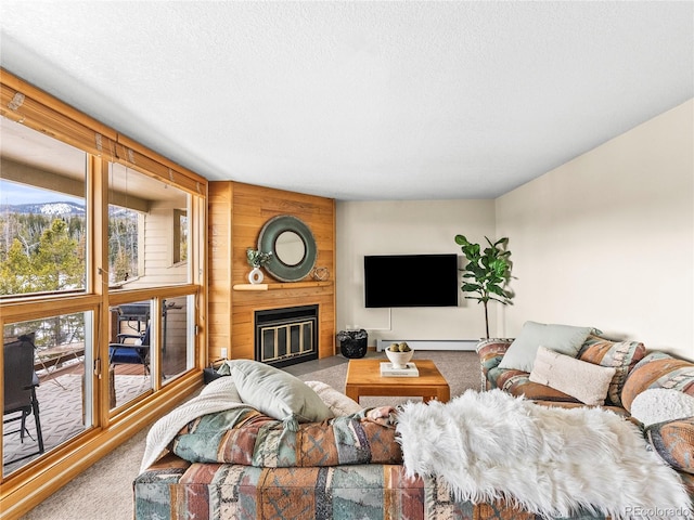 living room with a baseboard radiator, carpet flooring, a large fireplace, and a textured ceiling