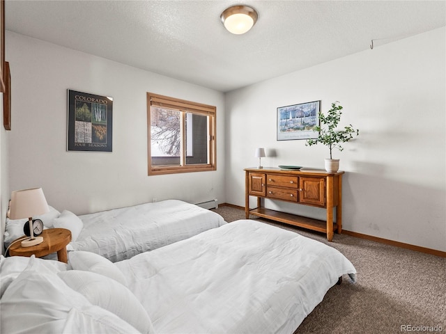 carpeted bedroom featuring a baseboard heating unit and a textured ceiling