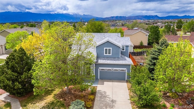 3618 Boot Spur Ct, Colorado Springs, CO 80922 - view of front of property featuring driveway, a mountain view, an attached garage, and a shingled roof