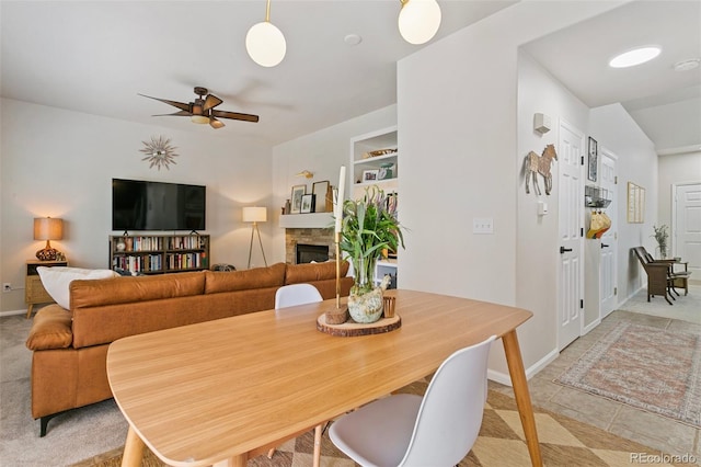 3618 Boot Spur Ct, Colorado Springs, CO 80922 - dining area with a ceiling fan, a stone fireplace, and baseboards